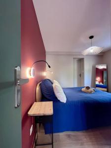 ブリーヴ・ラ・ガイヤルドにあるSublime & Unique Ranch d'exception - Proche Gare & Centre de Briveのベッドルーム1室(青いベッド1台、犬1匹付)
