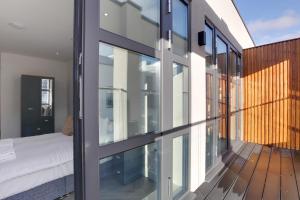 Zimmer mit Glastüren und einem Bett auf dem Balkon in der Unterkunft CityView Executive Apartments Southend in Southend-on-Sea