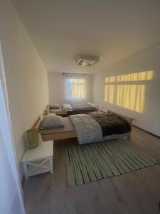 a bedroom with two beds and a rug at Viesu māja Stadula in Skrunda