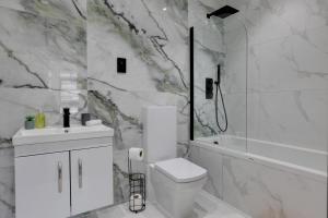 ein weißes Bad mit einem WC und einer Dusche in der Unterkunft CityView Executive Apartments Southend in Southend-on-Sea