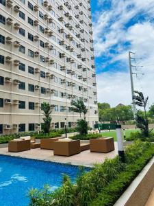 a large building with a pool in front of it at SMDC Green 2 Staycation in Dasma in Dasmariñas