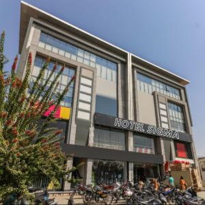 a building with motorcycles parked in front of it at Hotel Sigma in Ahmedabad