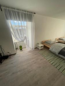 een slaapkamer met een bed en een groot raam bij Viesu māja Stadula in Skrunda