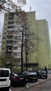 a large building with cars parked in a parking lot at Saska Kępa Luxe Apartment in Warsaw