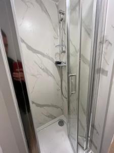 uma casa de banho com uma cabina de duche em vidro em Camden BNB em Londres