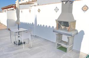 a fireplace in a room with a table and a chair at Chalet La Higuerita in Conil de la Frontera +7 photos
