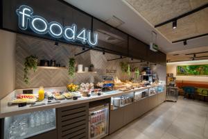 a restaurant with a buffet of food on a counter at Hotel Bed4U Pamplona in Cordovilla