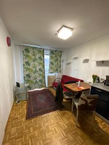 a small living room with a table and a kitchen at Wohnung in Bahnhofsnähe mit Balkon - 35 m2 in Gmunden