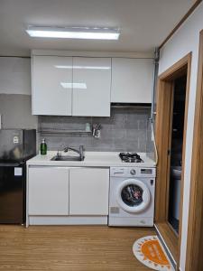 a kitchen with a sink and a washing machine at Urban Space Seolleung in Seoul