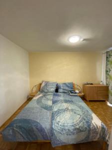 a bedroom with a bed with a blue comforter at Wohnung in Bahnhofsnähe mit Balkon - 35 m2 in Gmunden