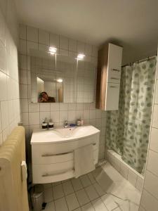 a white bathroom with a sink and a mirror at Wohnung in Bahnhofsnähe mit Balkon - 35 m2 in Gmunden