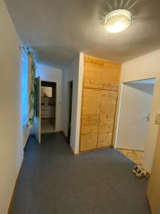 a hallway with a wooden door in a room at Wohnung in Bahnhofsnähe mit Balkon - 35 m2 in Gmunden