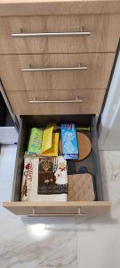 a drawer in a cabinet filled with books and cookies at City Hall studio apartment in Tríkala