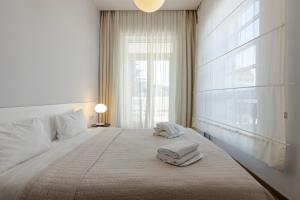 a bedroom with a large bed with towels on it at Le Port Boutique Apart Hotel in Batumi