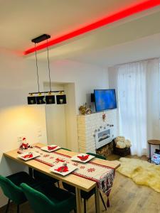 a dining room table with green chairs and a red beam at Ferienhaus Doina in Gehlberg