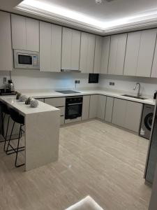 una grande cucina con armadi bianchi e bancone di Two-Bedroom Apartment a Riyad