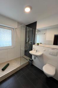 uma casa de banho com um chuveiro, um WC e um lavatório. em Pension Zwei A em Leverkusen