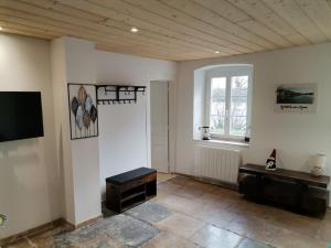 uma sala de estar com uma televisão e uma janela em L'Alcôve des Ondines em Rochefort-sur-Nenon