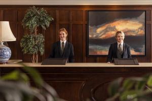 two men in suits sitting at a desk at Lough Eske Castle in Donegal