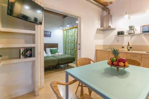 a kitchen and living room with a table with a bowl of fruit at Baluard-Apartment only 100 meters from the beach in Barcelona