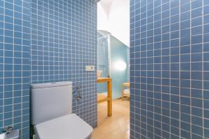 a bathroom with blue tiled walls and a toilet at Baluard-Apartment only 100 meters from the beach in Barcelona