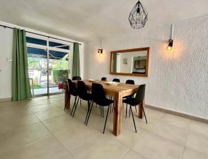 a dining room with a wooden table and black chairs at Lakaz' Tamier in Flic-en-Flac