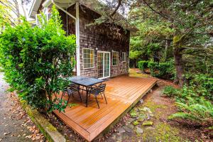 a wooden deck with a table and chairs on a house at Cozy Cannon Beach Condo in Cannon Beach