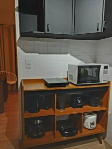 a microwave oven sitting on top of a counter at Studio116-completo, confortável, amplo, prático in Brasilia +10 photos
