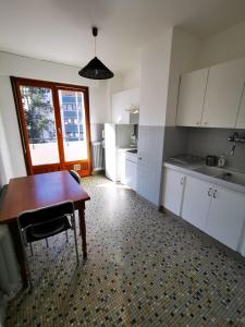 una cucina con tavolo in legno, lavandino e tavolo di Beau T1 Spacieux, Proche Centre et lac ad Annecy