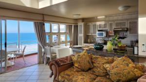sala de estar con sofá y cocina en Pelicans Pad at Chaka's Cove, en Ballito