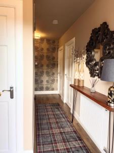 a hallway with a table and a rug at Auld Tom's Rest in St. Andrews