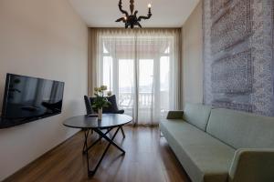 a living room with a couch and a table at Le Port Boutique Apart Hotel in Batumi