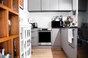 a kitchen with white cabinets and a stove top oven at Cosy house near the Parc Bordelais in Bordeaux