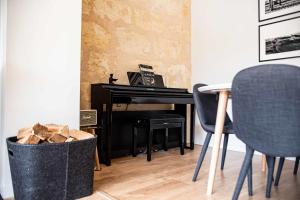 a room with a piano and chairs and a trash can at Cosy house near the Parc Bordelais in Bordeaux