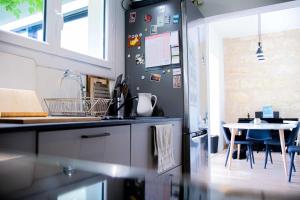 a kitchen with a refrigerator and a table at Cosy house near the Parc Bordelais in Bordeaux