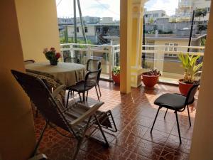a room with a table and chairs on a balcony at La villa de christiane in Grand Baie