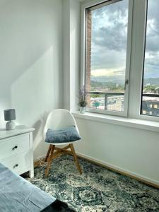 um quarto com uma cadeira em frente a uma janela em Lokstadt em Winterthur