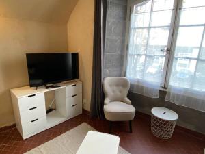 un salon avec une télévision et une chaise dans l'établissement NEW Grand Studio Plein centre Clermont-Ferrand, à Clermont-Ferrand