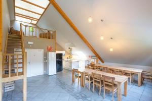 a kitchen and dining room with wooden tables and chairs at Au Coeur du Bois in Rendeux