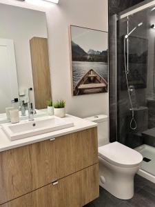 La salle de bains est pourvue d'un lavabo, de toilettes et d'une douche. dans l'établissement Verbier New Luxurious Condo 2bdrm spa-pool-sauna, à Mont-Tremblant