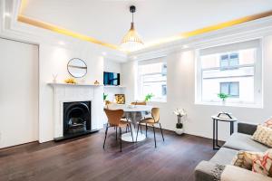 a living room with a table and a fireplace at Welcome London Covent Garden in London
