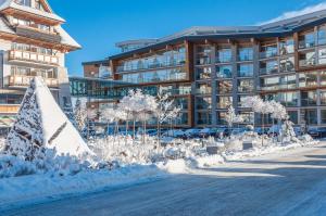 un edificio con un patio cubierto de nieve delante de él en Rezydencja Nosalowy Dwór, en Zakopane