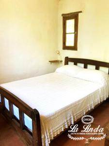 2 camas individuales en un dormitorio con ventana en Casa Eco La Linda San Marcos Sierras en San Marcos Sierras