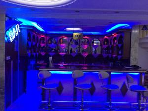 un bar con luci blu e sgabelli in una stanza di Hotel Grand Mark a Istanbul
