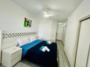 ein Schlafzimmer mit einem blauen Bett und Handtüchern darauf in der Unterkunft Santa Maria Ocean View in Adeje