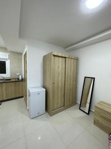a room with a refrigerator and a wooden cabinet at Karak Plaza Apartments in Kerak