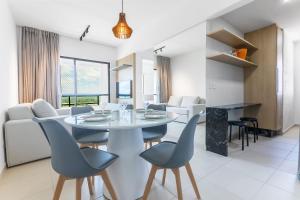 a dining room and living room with a table and chairs at Áurea Guedes #901A - Apartamento por Carpediem in Natal