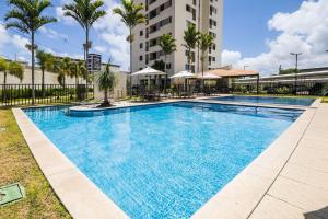 a large swimming pool in front of a building at Áurea Guedes #901A - Apartamento por Carpediem in Natal