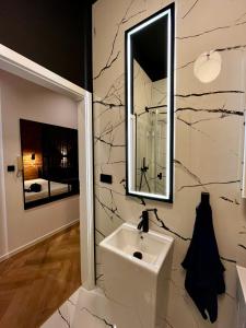 ein Bad mit einem Waschbecken und einem Spiegel in der Unterkunft Polpo Apartments - Kilinskiego 33 in Łódź