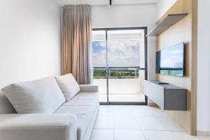 a living room with a couch and a large window at Áurea Guedes #901A - Apartamento por Carpediem in Natal